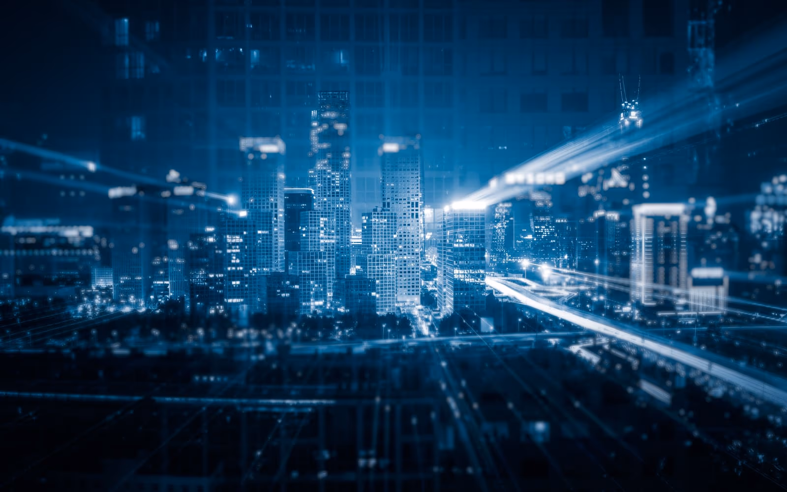 A city skyline at night rendered in blue with streaks of light suggesting data traffic.